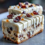 Glazed Cranberry Bliss Bars topped with dried cranberries, perfect for holiday dessert trays or coffee breaks.