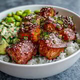 Flaky marinated salmon nestled in warm jasmine rice with edamame, cucumber, and creamy avocado, drizzled spicy mayo.