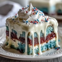 Festive Patriotic Poke Cake with creamy white chocolate ganache, ready to celebrate.